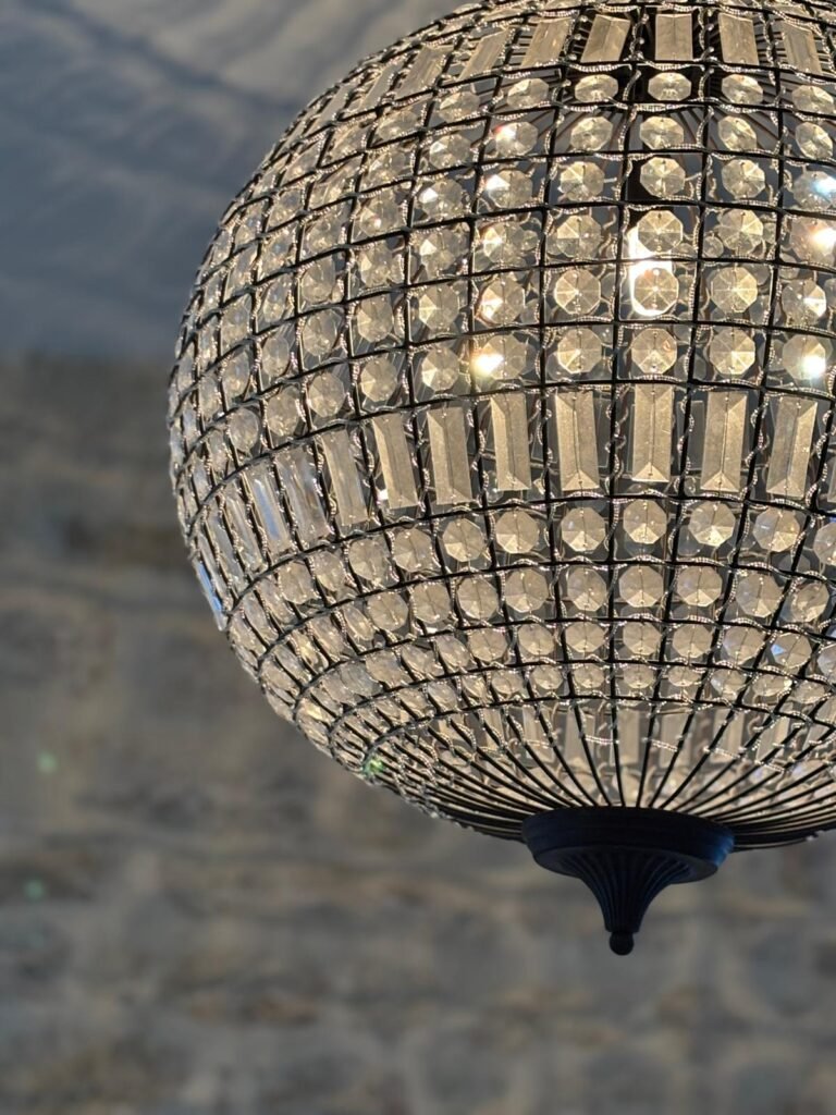 Le lustre surplombe l'escalier en pierre d'accès à la chambre d'hôtes La Parenthèse à Chamarandes Choignes.